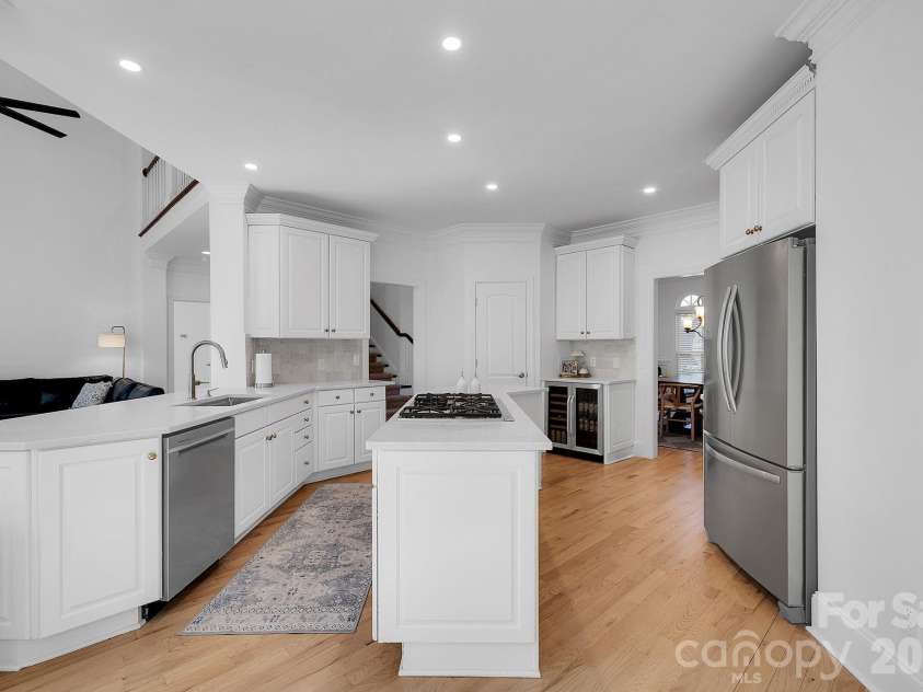 7778 Burning Ridge Drive, Stanley, NC 28164.  MLS# CAR4336313, YatesRealty ID 13726. Bright kitchen designed with white cabinetry, quartz countertops, and a large center island with gas cooktop. Open layout connects seamlessly to adjacent living areas.