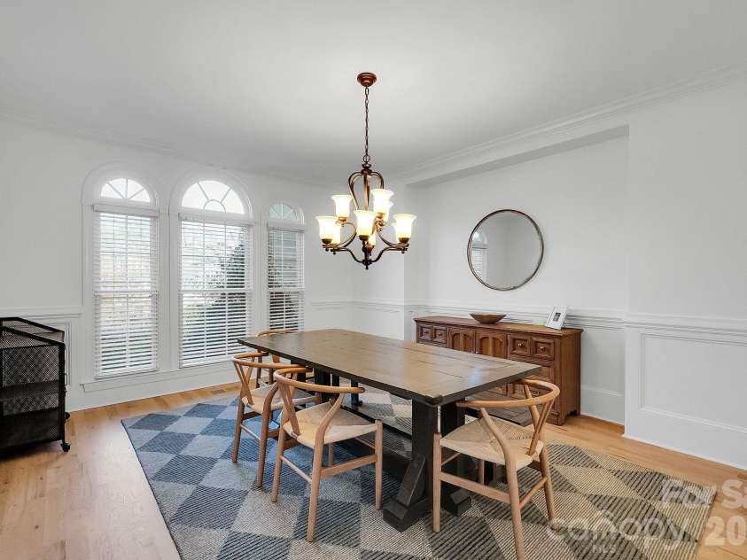 7778 Burning Ridge Drive, Stanley, NC 28164.  MLS# CAR4336313, YatesRealty ID 13726. Formal dining room highlighted by arched windows, decorative millwork, and a statement chandelier. The space offers an inviting setting for gatherings and entertaining