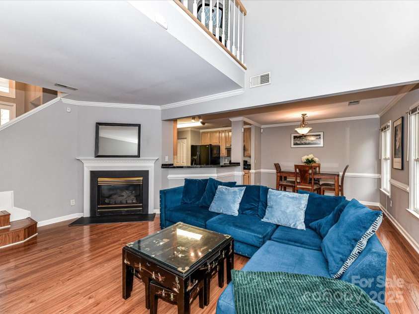 4743 Morning Dew Court, Charlotte, NC 28269.  MLS# CAR4244275, YatesRealty ID 13756. Open and airy Living Room with cozy fireplace, vaulted ceiling with loft overlook, huge windows and elegant crown and chair moldings throughout.
