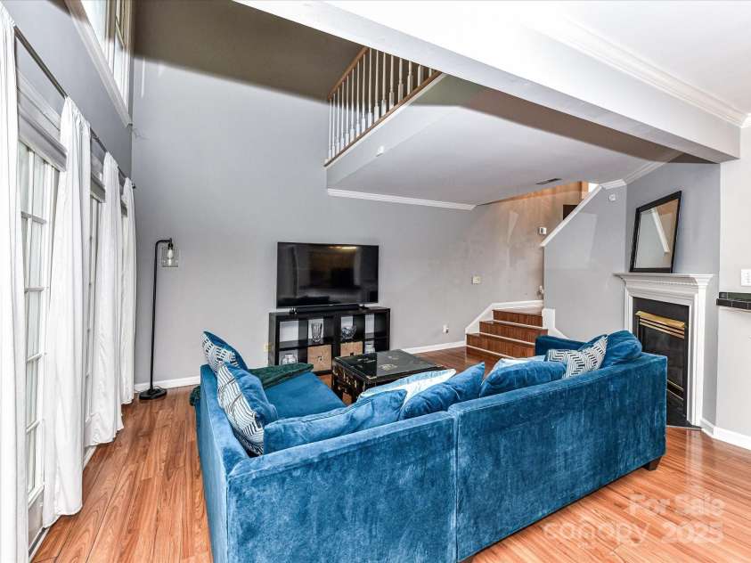4743 Morning Dew Court, Charlotte, NC 28269.  MLS# CAR4244275, YatesRealty ID 13756. Open and airy Living Room with cozy fireplace, vaulted ceiling with loft overlook, huge windows and elegant crown and chair moldings throughout.
