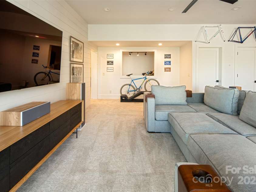 42 Spring Cove Road, Asheville, NC 28804.  MLS# CAR4246585, YatesRealty ID 13759. Family room adjoins a perfect flex space with passthrough (currently used as a home gym) and 2nd primary ensuite bedroom/bath and yet another office space (currently used for children's gaming stations!).