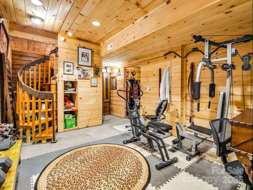 1002 CC Road, Rutherfordton, NC 28139.  MLS# CAR4249234, YatesRealty ID 13761. Spiral staircase brings you from the kitchen area, downstairs into the walk-out finished basement. (A portion of the floor by the stairs will be stained prior to closing).