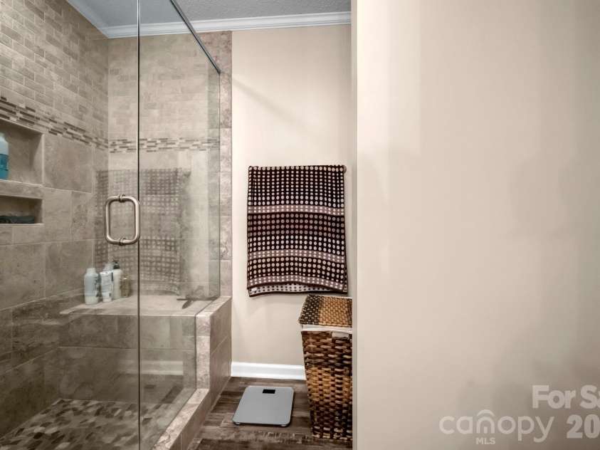 7812 Hwy 742 Highway, Marshville, NC 28103.  MLS# CAR4383299, YatesRealty ID 13761. Frameless glass shower with bench, cubbies, rain head, and tile flooring