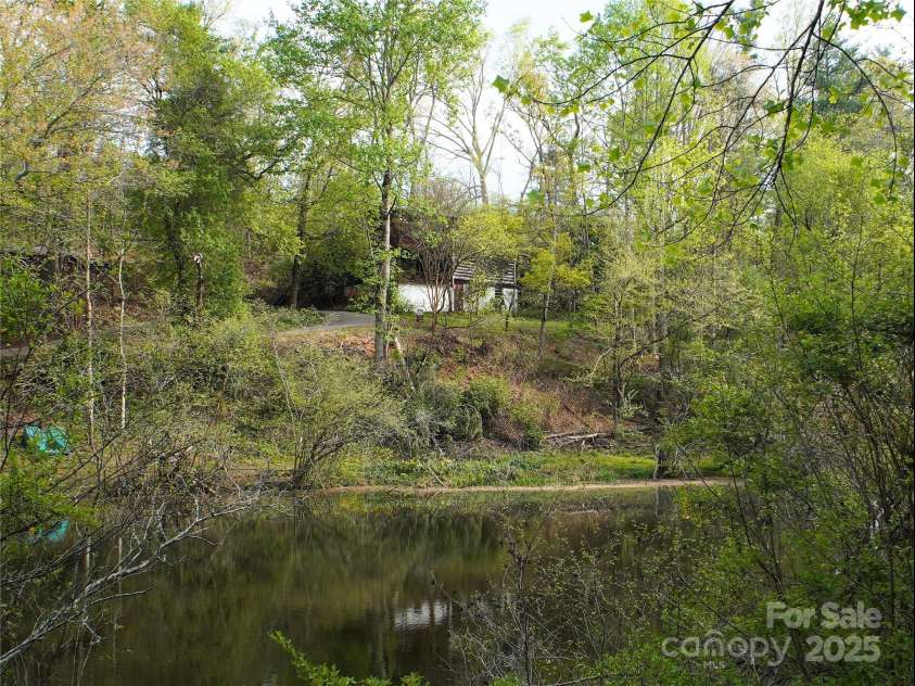 28 Fore Road, Asheville, NC 28806.  MLS# CAR4206820, YatesRealty ID 13803. View of the house from the other side of the pond