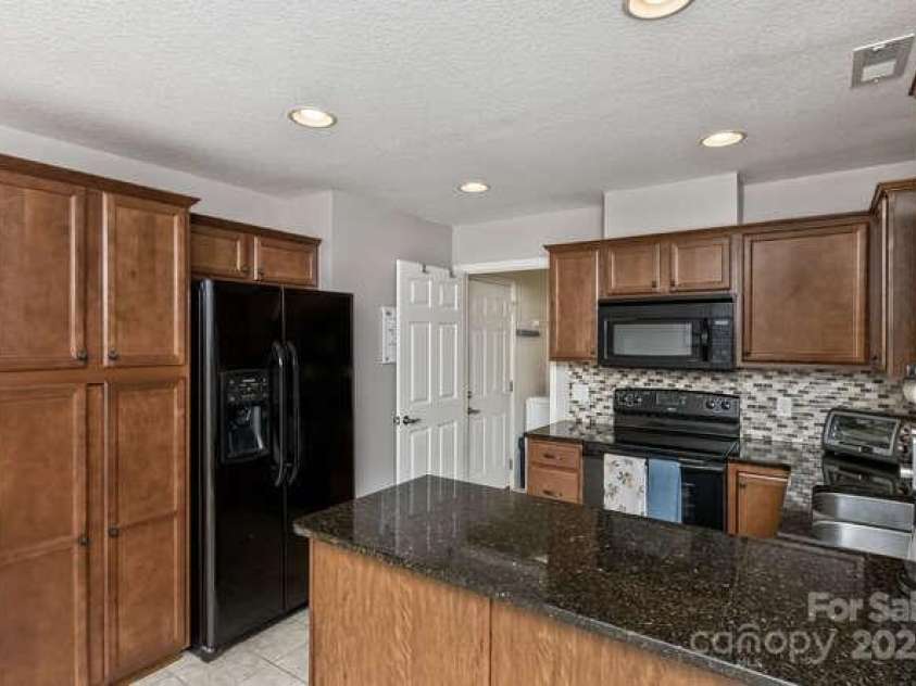 43 Sunny Meadows Boulevard, Arden, NC 28704.  MLS# CAR4249909, YatesRealty ID 13867. A handsome kitchen with natural stone counters and matching backsplash.