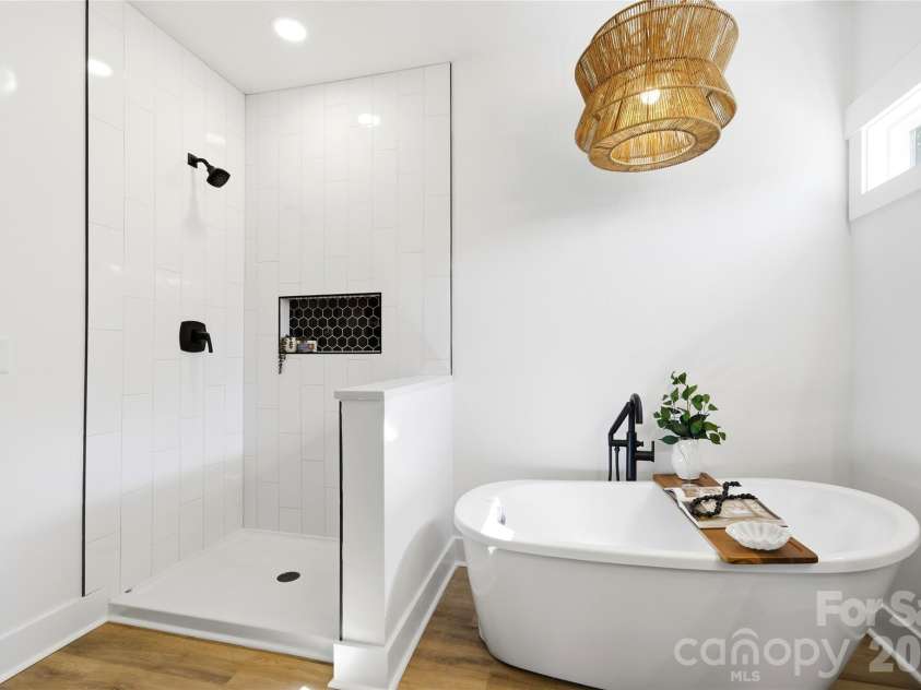 356 Main Street, McAdenville, NC 28101.  MLS# CAR4315707, YatesRealty ID 1389. Spa-inspired primary bath featuring a freestanding soaking tub, oversized tiled walk-in shower with designer niche, matte black fixtures, and elevated finishes designed for everyday luxury. *glass to be installed*