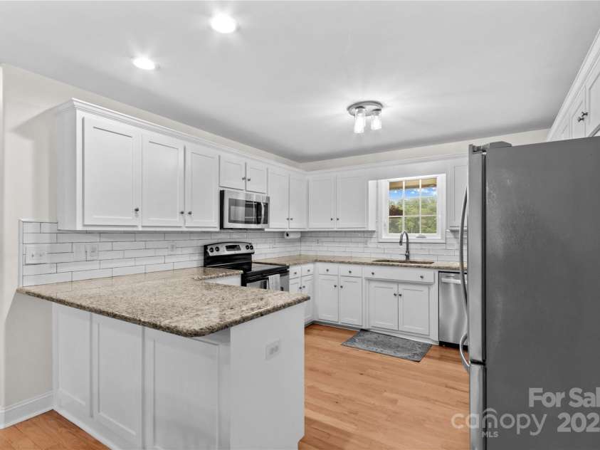 4336 Hunter Rhyne Road, Lincolnton, NC 28092.  MLS# CAR4257970, YatesRealty ID 13917. Kitchen with granite counter tops, white shaker cabinets, stainless steel microwave, smooth top electric range and dishwasher