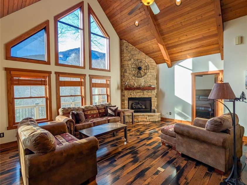 13 Miners Trace Road, Burnsville, NC 28714.  MLS# CAR4206928, YatesRealty ID 13994. Gorgeous Brazilian hardwood floors flow seamlessly throughout the main level, warmed by the inviting glow of a stone fireplace – the perfect focal point for cozy evenings.