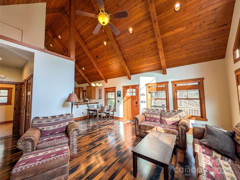 13 Miners Trace Road, Burnsville, NC 28714.  MLS# CAR4206928, YatesRealty ID 13994. The tongue-and-groove vaulted ceiling, accented by exposed beams, adds a touch of rustic elegance that elevates the space beyond mere comfort.