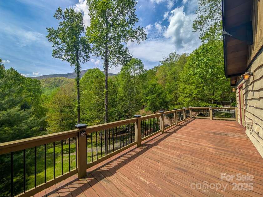 13 Miners Trace Road, Burnsville, NC 28714.  MLS# CAR4206928, YatesRealty ID 13994. The vast front deck, a perfect spot for morning coffee or evening stargazing, beckons you to embrace the natural splendor that surrounds you.