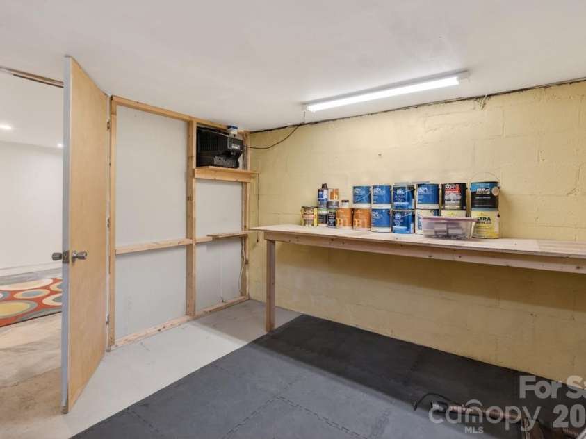 95 Whitney Avenue, Tryon, NC 28782.  MLS# CAR4354640, YatesRealty ID 14002. Basement utility room with workbench