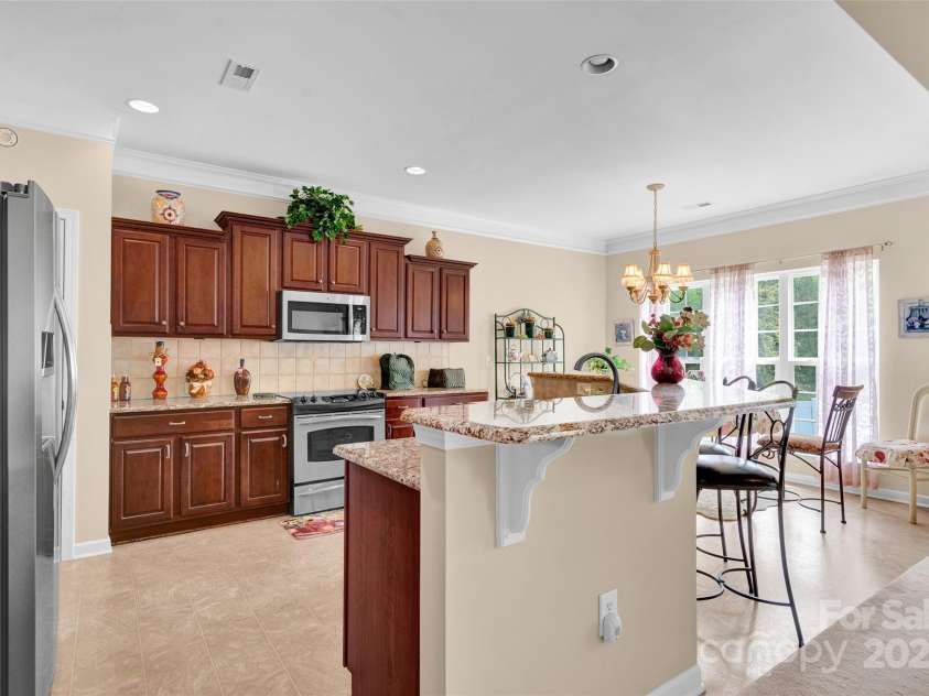 141 Ivy Creek Lane, Mooresville, NC 28115.  MLS# CAR4246190, YatesRealty ID 14012. Another view of the kitchen.  Tiered wood cabinets and recessed lighting
