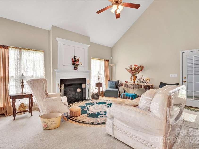 141 Ivy Creek Lane, Mooresville, NC 28115.  MLS# CAR4246190, YatesRealty ID 14012. Family room with access to back covered patio.  TV opening above the fireplace and vaulted ceilings to upper level