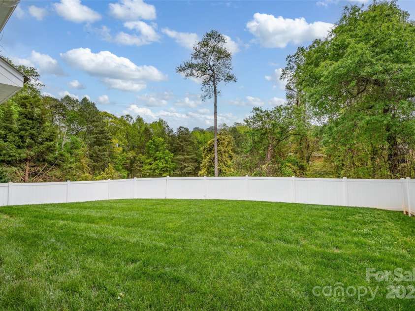 141 Ivy Creek Lane, Mooresville, NC 28115.  MLS# CAR4246190, YatesRealty ID 14012. View of fenced backyard and private wooded area beyond