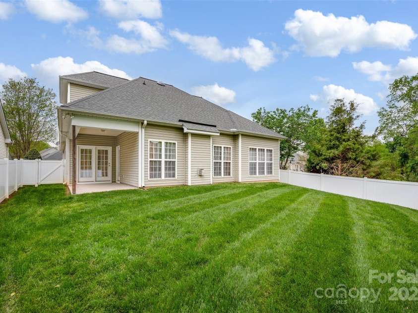 141 Ivy Creek Lane, Mooresville, NC 28115.  MLS# CAR4246190, YatesRealty ID 14012. View of the back yard with fenced privacy and cover back patio area.  Lawn taken care of by the HOA!