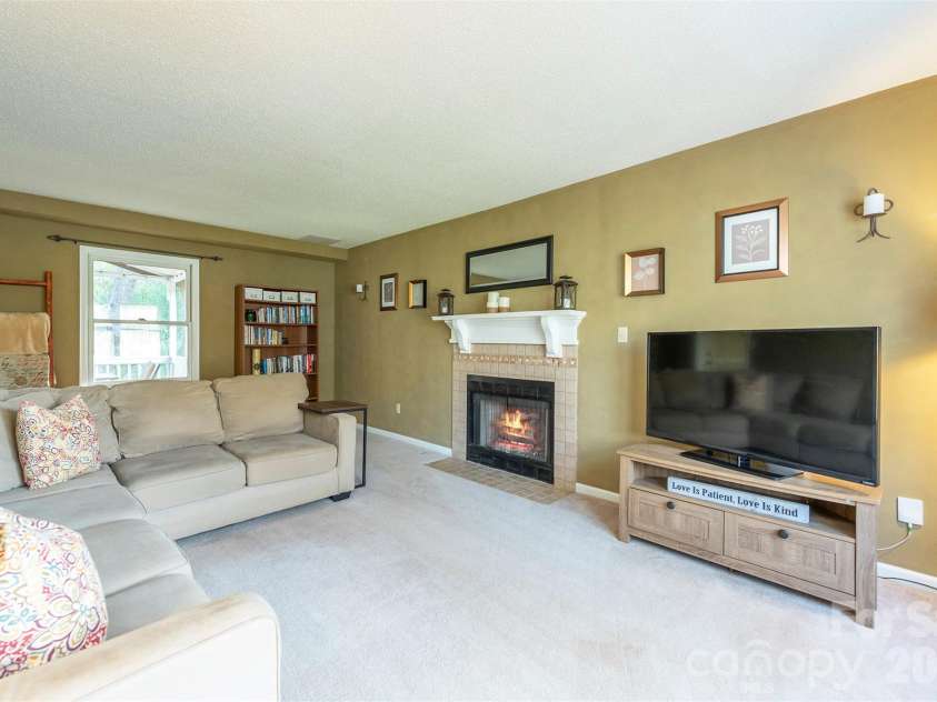46 Foxberry Drive, Arden, NC 28704.  MLS# CAR4341597, YatesRealty ID 14016. An inviting living room, ideal for family gatherings by the cozy fireplace