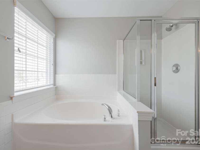 10008 King George Lane, Waxhaw, NC 28173.  MLS# CAR4257017, YatesRealty ID 14025. Indulge in the spa-like retreat of a serene garden soaking tub and private shower, an ideal sanctuary for a soothing bubble bath, candles, and a glass of wine—because sometimes, you just need a 