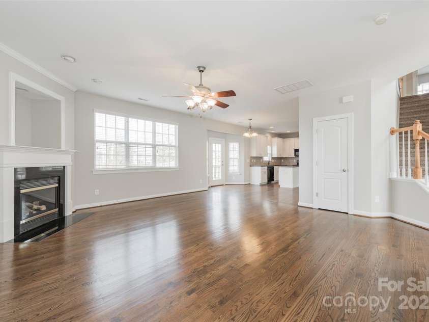 10008 King George Lane, Waxhaw, NC 28173.  MLS# CAR4257017, YatesRealty ID 14025. The expansive sun drenched Great Room, featuring a wall of windows, gleaming hardwood floors and a cozy gas fireplace, offers breathtaking views of the private, tree-lined backyard and seamlessly flows into the open-co