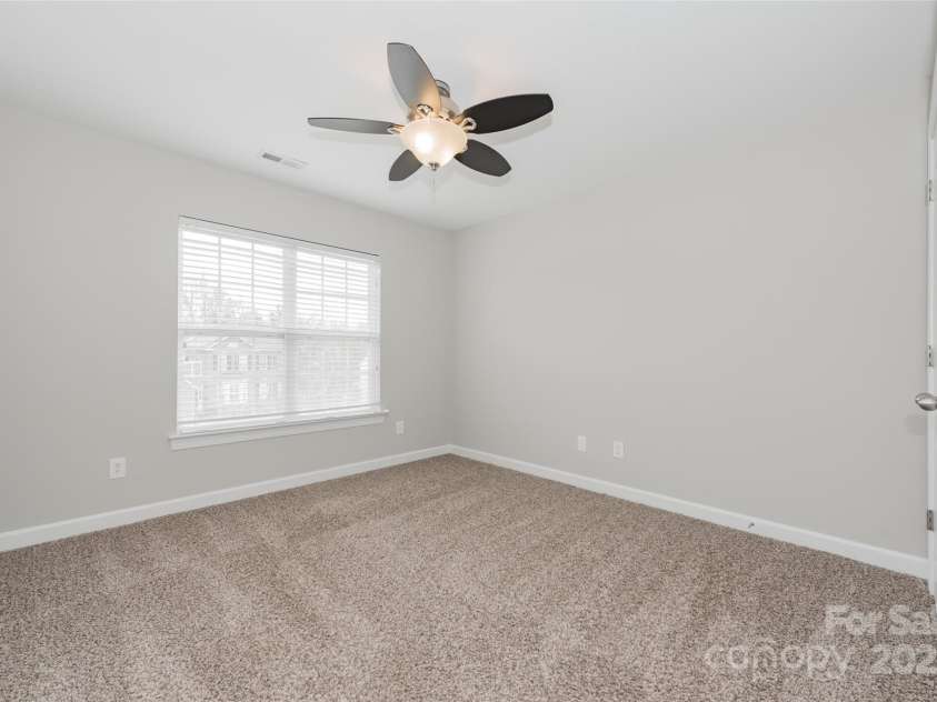 10008 King George Lane, Waxhaw, NC 28173.  MLS# CAR4257017, YatesRealty ID 14025. The front bedroom, bathed in sunlight and featuring dual closets, is a spacious and inviting retreat, perfect for relaxing or creating your ideal personal space.