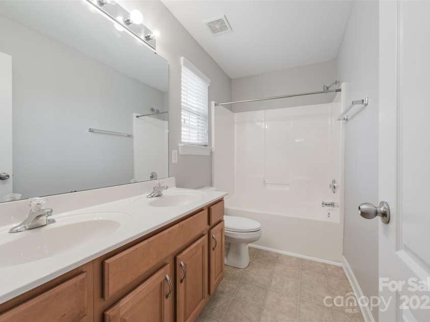 10008 King George Lane, Waxhaw, NC 28173.  MLS# CAR4257017, YatesRealty ID 14025. The hall bathroom features dual sinks, a tranquil view of the tree-lined backyard, and plenty of space—perfect for when you need room to get ready without any bathroom squabbles!