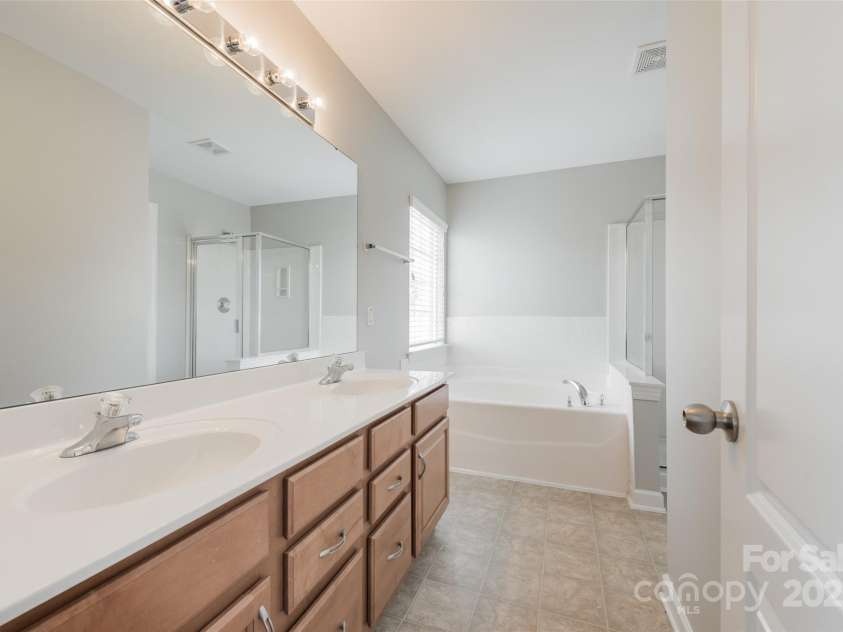 10008 King George Lane, Waxhaw, NC 28173.  MLS# CAR4257017, YatesRealty ID 14025. The master bathroom offers ample counter space, dual sinks, and plenty of mirror time—because why argue over space when elegance and convenience are built in?