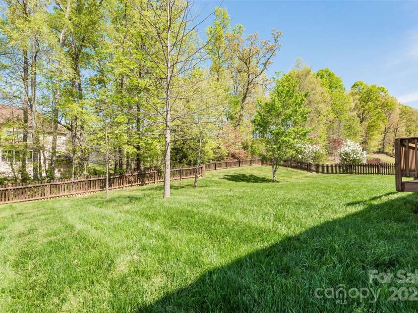 10008 King George Lane, Waxhaw, NC 28173.  MLS# CAR4257017, YatesRealty ID 14025. This fantastic, private, fenced-in backyard, surrounded by towering mature hardwoods, offers the ultimate sanctuary for celebrations, where you can create a lifetime of joyful memories, enjoying intimate gatherings, la