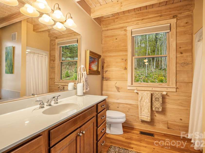 60 Laurel Lane, Mars Hill, NC 28754.  MLS# CAR4256396, YatesRealty ID 14054. Main level primary bathroom with walk-in shower and separate saoking tub.