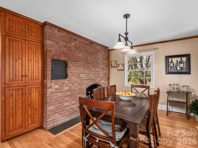 500 Griffing Boulevard, Asheville, NC 28804.  MLS# CAR4321674, YatesRealty ID 14158. The custom built-in cabinetry, solid brick wall with wood burning fireplace make this dining room charming!