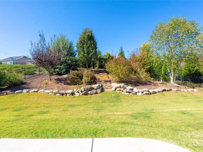 9026 Raven Top Drive, Mint Hill, NC 28227.  MLS# CAR4316455, YatesRealty ID 14246. A great view of the back yard landscaping.  The yard is level and then rises to a nutural area that is lovely and provides privacy.