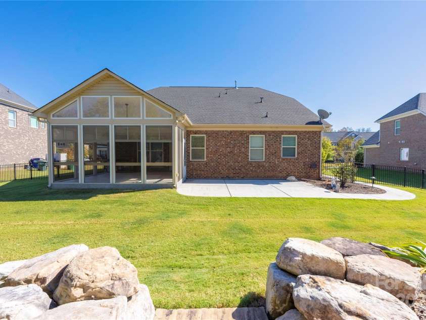 9026 Raven Top Drive, Mint Hill, NC 28227.  MLS# CAR4316455, YatesRealty ID 14246. A professionally landscaped back yard showcasing the three season room.