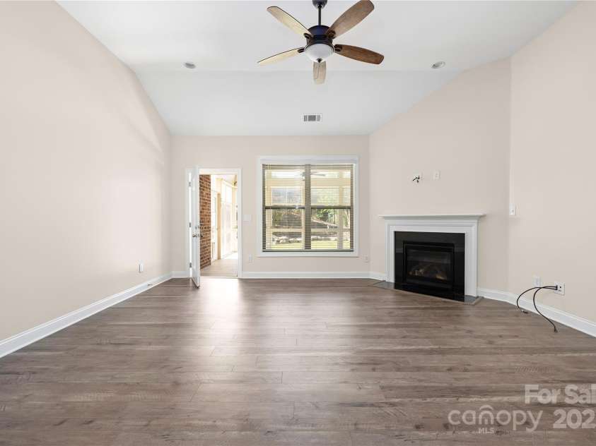 9026 Raven Top Drive, Mint Hill, NC 28227.  MLS# CAR4316455, YatesRealty ID 14246. Family room with hardwoods leads to the three season room.