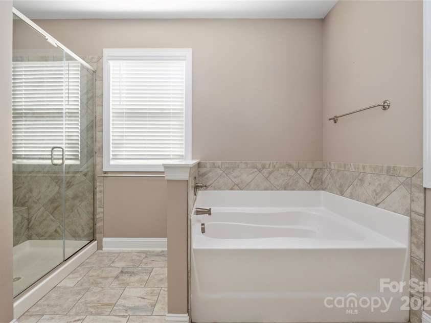 9026 Raven Top Drive, Mint Hill, NC 28227.  MLS# CAR4316455, YatesRealty ID 14246. Large separate tub and a glass door shower.