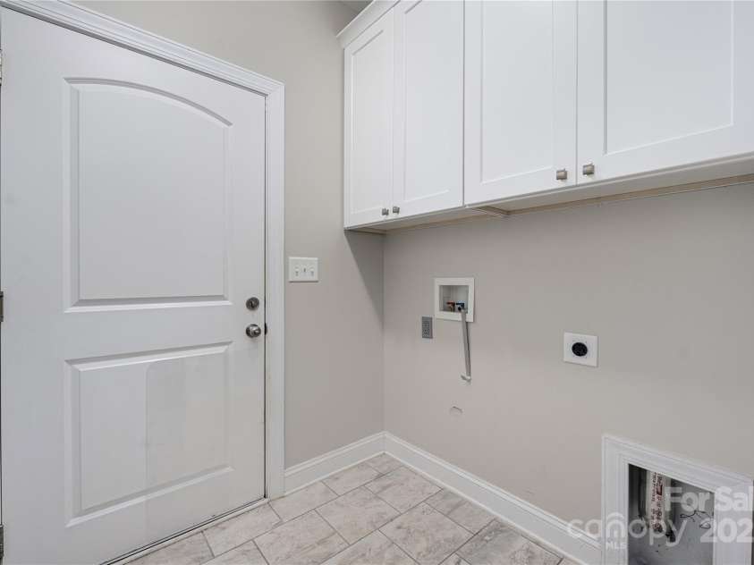 9026 Raven Top Drive, Mint Hill, NC 28227.  MLS# CAR4316455, YatesRealty ID 14246. Main level laundry room with cabinets and added cabinets for great storage.