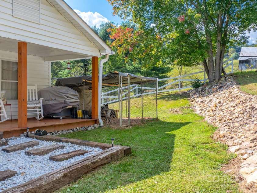 2906 Rabbit Skin Road, Waynesville, NC 28785.  MLS# CAR4183385, YatesRealty ID 14265. Front porch and dog kennel