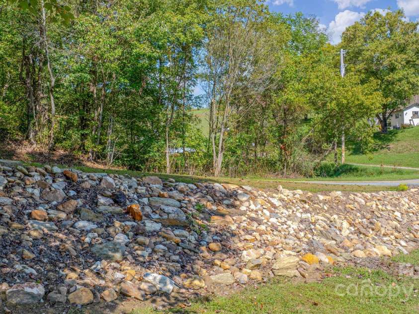 2906 Rabbit Skin Road, Waynesville, NC 28785.  MLS# CAR4183385, YatesRealty ID 14265. Rock wall in front of house
