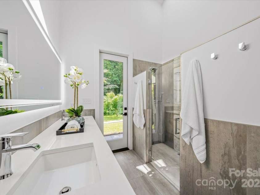 3304 Mar Vista Circle, Charlotte, NC 28209.  MLS# CAR4269142, YatesRealty ID 1429. Primary bath with operable skylight, floating dual vanity, backlit mirror, walk in tiled shower with rain shower head.  Prewired for drop down lighting and towel dryer. 