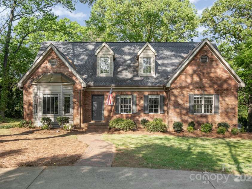 119 Lakenheath Lane, Matthews, NC 28105.  MLS# CAR4241430, YatesRealty ID 14292. Front of home framed by mature trees
