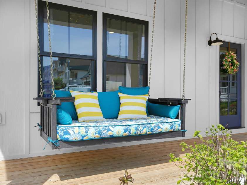 71 Hidden Pond Lane, Brevard, NC 28712.  MLS# CAR4367829, YatesRealty ID 14300. Relax and unwind on this inviting front porch, featuring a charming hanging daybed swing with vibrant cushions, perfect for morning coffee, afternoon reading, or enjoying peaceful Carolina evenings.