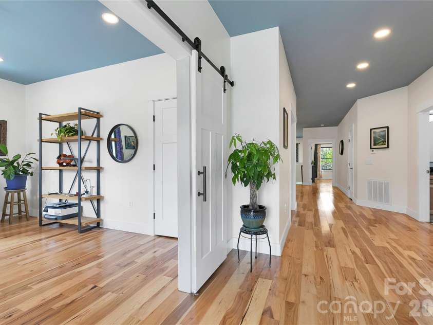 71 Hidden Pond Lane, Brevard, NC 28712.  MLS# CAR4367829, YatesRealty ID 14300. Step inside to a bright, inviting entryway featuring warm hardwood floors, clean modern lines, and a stylish sliding barn door that adds both character and functionality.