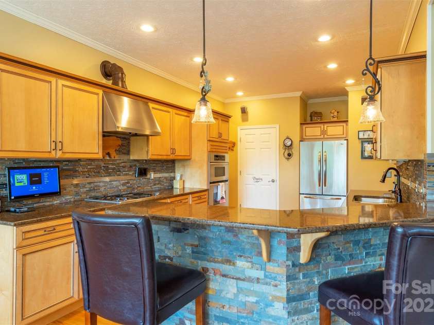 59 Carriage Highlands Court, Hendersonville, NC 28791.  MLS# CAR4243182, YatesRealty ID 14360. With a breakfast bar, this kitchen is ideal for casual dining and hosting friends.