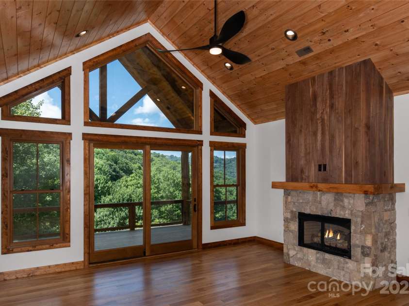 750 Silver Springs Drive, Banner Elk, NC 28604.  MLS# CAR4160928, YatesRealty ID 144. Vaulted living room with floor to ceiling sliding doors & windows and gas fireplace