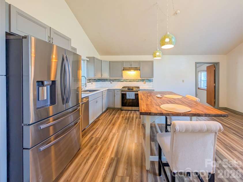 65 Happy Hollow Road, Green Mountain, NC 28740.  MLS# CAR4363965, YatesRealty ID 14402. Greatroom on upper level with updated kitchen (2022) breakfast bar, stainless steel appliance & gas range is beautiful sunshine bright open space! 