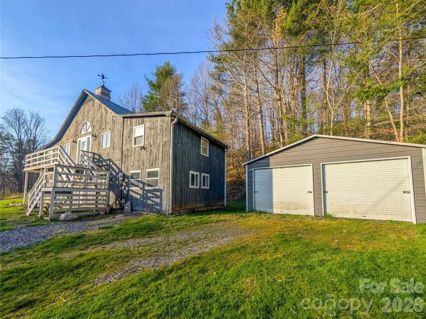 65 Happy Hollow Road, Green Mountain, NC 28740.  MLS# CAR4363965, YatesRealty ID 14402. Home that was originally a barn converted into a home with attached studio space/workshop, deck and detached 2 car metal garage currently used to store lawn maintenance equipment.