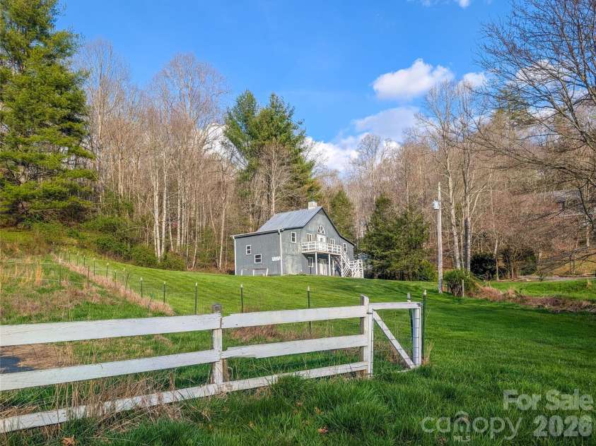 65 Happy Hollow Road, Green Mountain, NC 28740.  MLS# CAR4363965, YatesRealty ID 14402. View of home from fenced pasture area