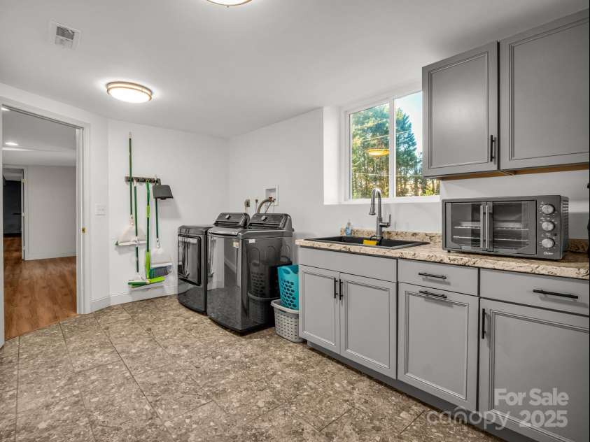 2115 Stoney View Court, Hendersonville, NC 28792.  MLS# CAR4310001, YatesRealty ID 14461. Versatile lower-level space complete with a full kitchenette, ample storage, and laundry area — ideal for in-laws, guests, or extended stays