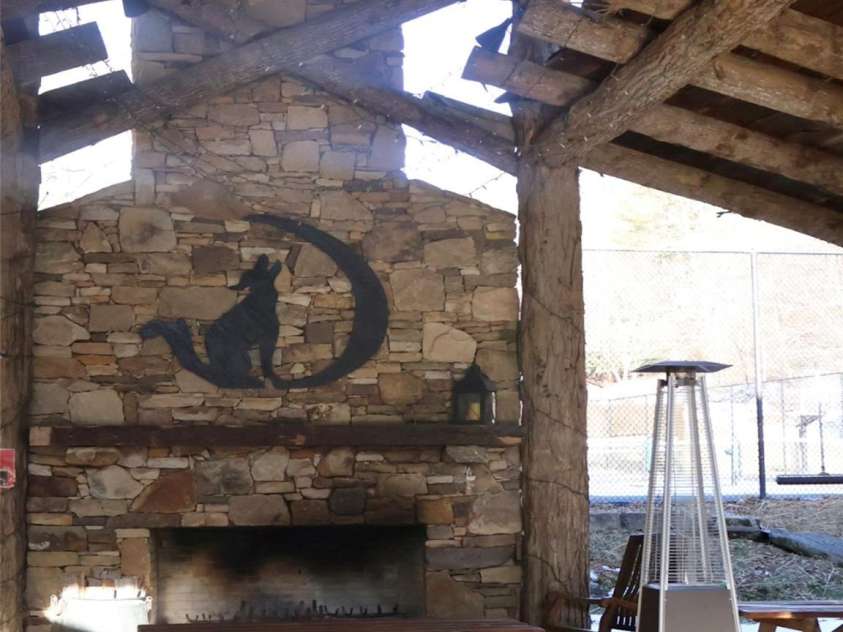 32 Zebulon Lane, Mars Hill, NC 28754.  MLS# CAR4336470, YatesRealty ID 1450. An enormous wood burning fireplace, surrounded by picnic tables is an inviting showpiece in the pavillion.