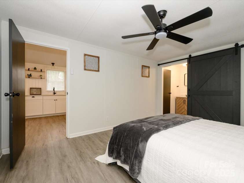 105 Mountain Brook Drive, Bessemer City, NC 28016.  MLS# CAR4237868, YatesRealty ID 14590. Another view of primary bedroom with bath on the right and living area out the door.  New black hardware, ceiling fan.