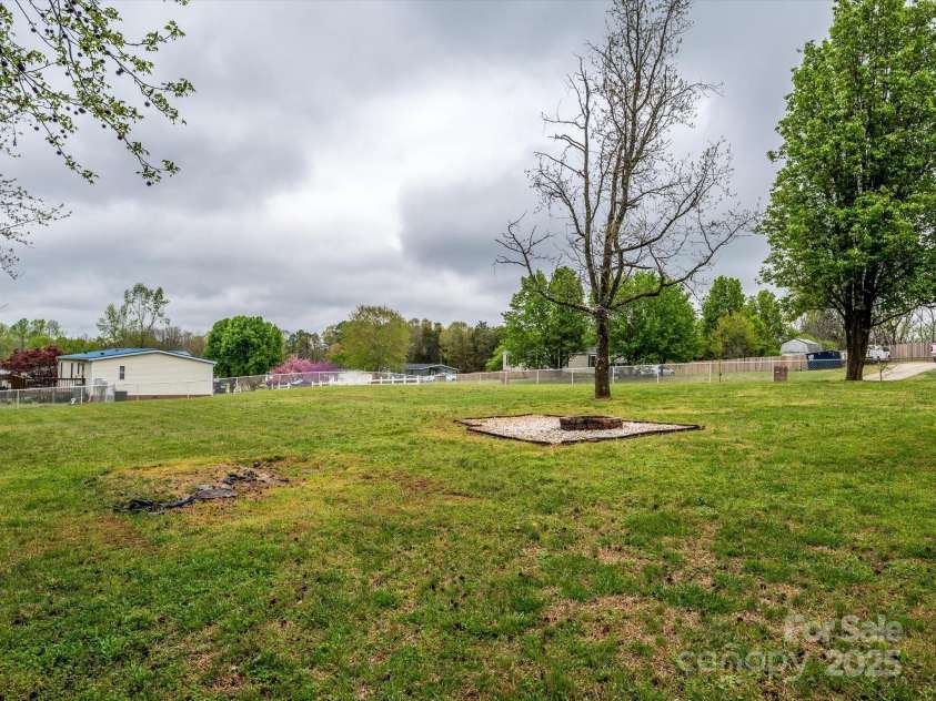 105 Mountain Brook Drive, Bessemer City, NC 28016.  MLS# CAR4237868, YatesRealty ID 14590. GINORMOUS fenced side yard to the right of the building with fire pit.