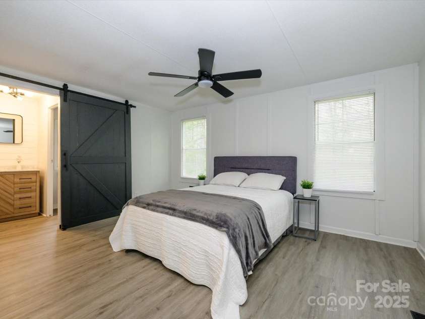 105 Mountain Brook Drive, Bessemer City, NC 28016.  MLS# CAR4237868, YatesRealty ID 14590. Primary suite with barn door accents looking onward into bath.