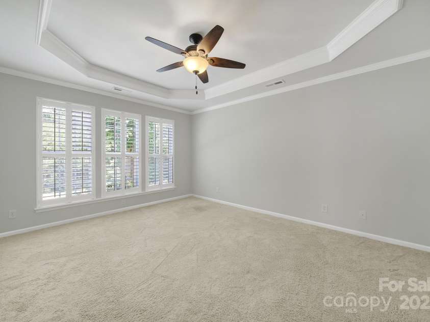 8107 Crater Lake Drive, Indian Land, SC 29707.  MLS# CAR4233120, YatesRealty ID 14662. Primary bedroom - ceiling fan, overlooking wooded back yard & patio.